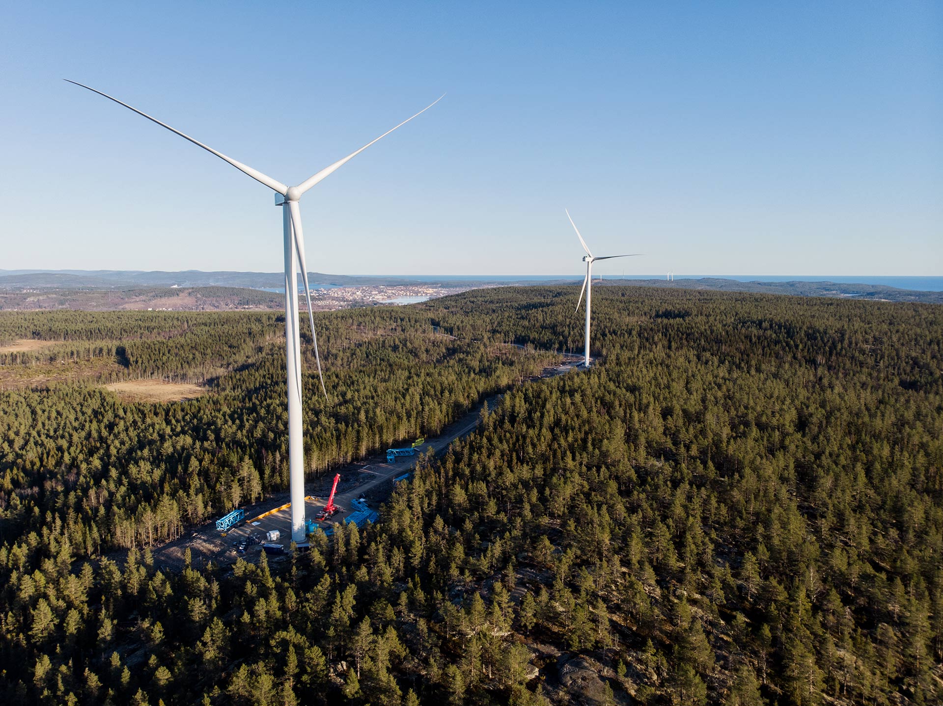 Två vindkraftverk på plats på Spjutåsberget med Härnösand i bakgrunden